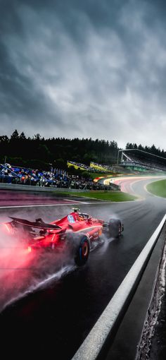 two racing cars on a race track in the rain