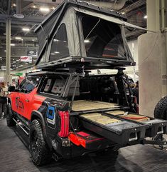 a truck with a tent on the back of it's bed in a building