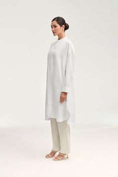 Elevate your summer wardrobe with our luxurious Linen Longline Button Down Top in White. Crafted from cool and breezy linen, this tunic-length cover up is perfect to wear as a standalone piece or a stylish layering option. Embrace effortless elegance in our white button down top. Model is 5'7" and is wearing size XS. Elegant Oversized Shirt Dress For Beach, Spring Workwear Tunic With Buttons, Chic Button-up Linen Dress For Daywear, Spring Button-up Tunic For Workwear, Chic Button-up Tunic For Spring, Chic Spring Button-up Tunic, Chic Oversized Linen Dress For Daywear, Spring Linen Long Shirt Dress, Spring Long Linen Shirt Dress