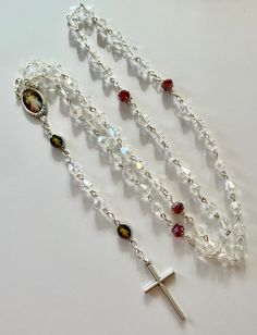 handmade with 6mm bicone crystal and red rondelle crystallized Swarovski elements beads, silver tone jump ring and chain, colored Divine Mercy rosary center piece eye pins and plain crucifix (Italy) It's about 22 inches long Note: The color might be slightly different due to lighting effect Crystal Necklaces With Silver Beads For Gift, Crystal Necklaces With Silver Beads As Gift, Clear Beaded Crystals For Gift, Adjustable Silver Rosary With Faceted Beads, Silver Rosary With Faceted Beads For Gift, Silver Rosary With Faceted Beads, Silver Rosary With Faceted Beads As Gift, Silver Rosary With Faceted Round Beads, Silver Crystals 8mm Beads For Gift