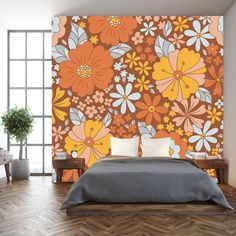 a bed sitting in a bedroom next to a wall with flowers painted on the walls