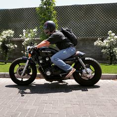 a man riding on the back of a black motorcycle