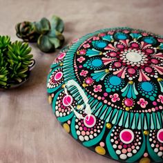 there is a small potted plant next to a decorative round pillow on the table