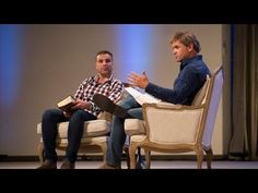 two men sitting in chairs talking to each other