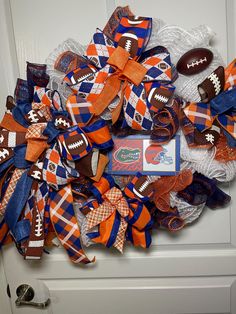 a wreath made out of footballs and other sports related items is on the front door