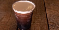 a plastic cup sitting on top of a wooden table