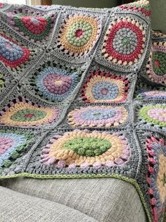 a crocheted granny blanket is sitting on a couch