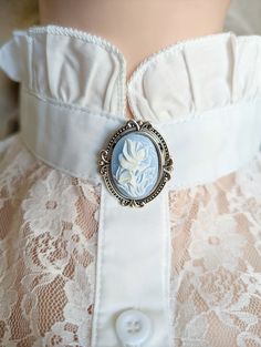 This elegant rose brooch features an ornate vintage-style setting. This beautiful Victorian Jewelry pin features a cameo with a delicate white rose relief on a baby blue background. Size: 1 3/8" (34 mm) long and just over 1 3/16" (30 mm) wide. All metal is plated brass. *Care instructions are simple - Please avoid contact with beauty products/sprays as they can dull the finish. * Ethically Sourced from US & Canadian raw materials * Meticulously handcrafted especially for you! * Arrives in a beau White Cameo Brooch For Formal Occasions, White Cameo Brooches For Formal Occasion, Victorian Style White Cameo Brooches, Victorian Style White Cameo Brooch, White Cameo Brooch For Wedding, White Cameo Brooches For Wedding, White Cameo Wedding Brooches, Vintage White Cameo Brooch, Vintage White Cameo Brooches