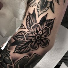 a close up of a person's arm with flowers and birds in the background