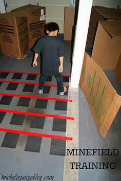 a young boy is standing on the floor in front of some moving boxes and tape