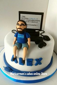 a cake with a man sitting on top of it that says alex next to a computer