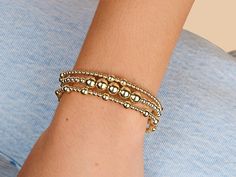 This alternating bead bracelet harmoniously combines 3mm and 5mm beads in a symphony of symmetry and shine. The elegant arrangement of golden spheres makes it an understated yet luxurious accessory that transitions seamlessly from casual to formal wear. 14K gold filled. Smaller bead size: 3mm. Larger Bead size: 5mm. 6.75 inch strong stretchy elastic band. Hypoallergenic, waterproof and tarnish resistant. Classic Beaded Bracelets With Polished Beads, Classic Polished Beaded Bracelets, Elegant Rosary Bracelet With Spacer Beads, Elegant Gold Rosary Bracelet With Spacer Beads, Elegant Gold Stretch Bracelet With Spacer Beads, Classic Gold Beaded Bracelets With Spacer Beads, Elegant Stretch Bracelet With 14k Gold-filled Gold Beads, Elegant Adjustable 14k Gold-filled Beaded Bracelet, Gold Stretch Bracelet With 14k Gold-filled Beads