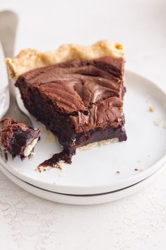 a piece of chocolate pie sitting on top of a white plate