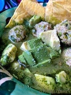 a bowl filled with green food and tortilla chips