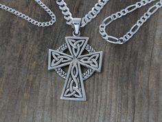 a celtic cross necklace on a wooden surface