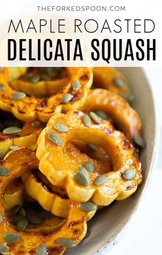 roasted delicata squash in a bowl with pumpkin seeds on top and text overlay