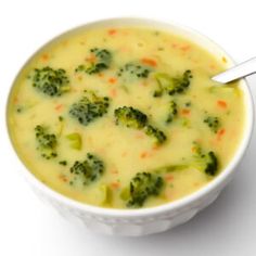 a bowl of soup with broccoli and carrots in it on a white background