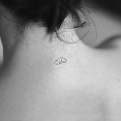 the back of a woman's neck with a small tattoo on it