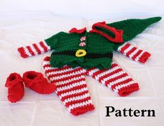 a crocheted christmas outfit and booties on a bed