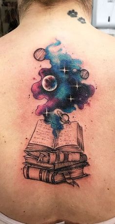 the back of a woman's neck with an open book and planets on it