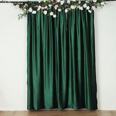 a green curtain with white flowers hanging from it