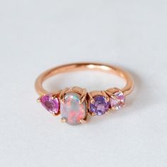 Our Splice Ring has been set with a solid semi black opal from Lightning Ridge and shades of pink to purple toned sapphires. Semi black opal measures 7 x 5mm. Band width 1.8mm. Gold weight in 14ct 3.1g approx. Please note, we will match the opal as close to the image as possible, but each Opal is unique and may vary in appearance and colour from what is depicted on the site. Opal And Amythest Ring, Ring Ideas, Jewellery Ideas, Lightning Ridge, Green Sapphire, Pretty Wedding, Shades Of Pink, Black Opal, Cluster Ring