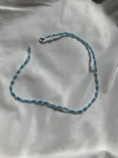 This necklace is made of blue seed beads and small pearls with a clasp. The beads are small for a cute minimalist look while still having a sophisticated and preppy look. They really fit in with the outer banks style which is so trendy at the moment! It can be styled with so many pieces to make any outfit really cute and trendy. This vsco style is so popular at the moment and this necklace is the perfect fit for that! Something that kiara from outer banks might wear! Gift for him, gift for her p Blue Tiny Beads Choker For Summer, Casual Blue Necklace With Tiny Beads, Casual Blue Letter Beads Necklace, Blue Pearl Beaded Necklaces For Beach, Blue Dainty Beaded Choker Necklace, Dainty Blue Beaded Choker Necklace, Casual Blue Choker With Colorful Beads, Blue Beaded Choker For Summer, Blue Single Strand Beaded Necklace For Summer