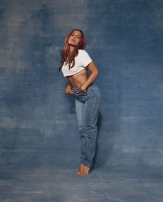 a woman in white shirt and jeans posing