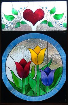 two stained glass windows with tulips and hearts in the window sill behind them