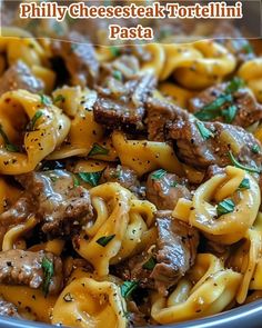 a bowl filled with pasta and meat covered in sauce