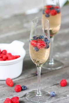 two wine glasses filled with berries and blueberries