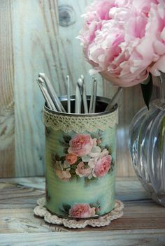 a vase with flowers and pens in it on a table