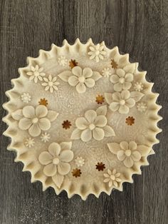 a white plate with flowers on it sitting on a wooden table