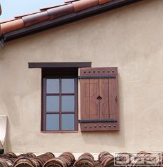 a group of people standing next to each other in front of a building with wooden shutters