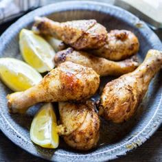 chicken legs with lemon wedges on a plate