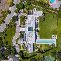 an aerial view of a large house with a swimming pool in the middle of it