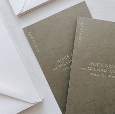 two wedding programs are sitting next to an envelope