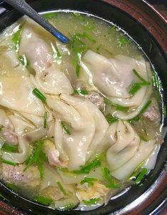 a bowl filled with dumplings and meat in broth