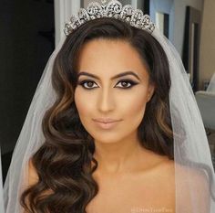 a woman in a wedding dress with a tiara on her head and long hair