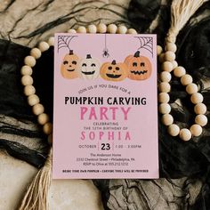 a pink party card with pumpkins on it next to a string of wood beads