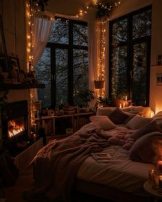 a bedroom with lights strung from the ceiling and a bed in front of a window