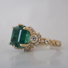 Bring elegance and sophistication to your jewelry collection with this one of a kind Emerald Knightsbridge Diamond Ring. Handcrafted in your choice of 14K and 18K Gold, this regal piece features a stunning natural emerald centerpiece surrounded by dazzling diamonds. As impressive as it is dreamy, this ring is sure to become a treasured family heirloom. Only one available. 14K or 18K solid gold Natural asscher cut emerald. 4.44 carat weight. Comes with a certificate. Natural round white diamonds. Exquisite Yellow Gold Cluster Ring, Elegant 14k Stamped Emerald Ring, Exquisite 14k Gold Cluster Ring, Luxury Gold Emerald Ring For Wedding, Timeless Gold Emerald Ring For Wedding, Gold Emerald Wedding Ring, Timeless Style, Luxury 14k Gold Cluster Ring, Luxury 14k Gold Emerald Wedding Ring, Luxury 14k Gold Ring With Intricate Design