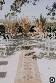 an outdoor ceremony setup with chairs and rug