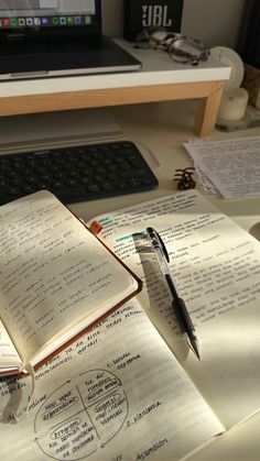 an open book sitting on top of a desk next to a laptop computer