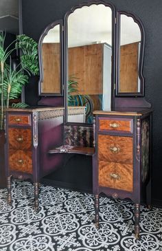 an antique dresser with mirror and potted plant