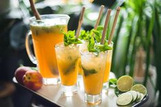 three glasses filled with drinks sitting on top of a tray