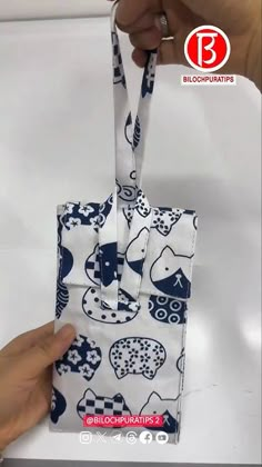 someone is holding up a small bag with an elephant pattern on the front and side