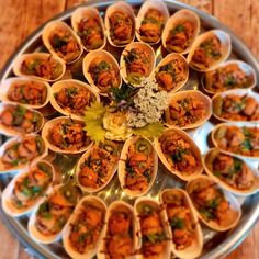 a platter filled with lots of food on top of a wooden table