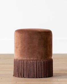 a brown ottoman sitting on top of a wooden floor