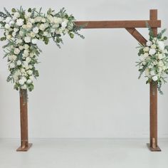 an arch decorated with white flowers and greenery